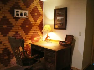 lamp on reading table with chair and pictures on wall