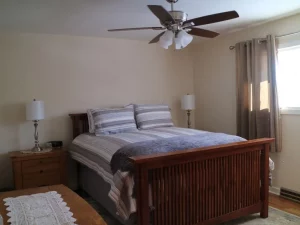 Bed with side table, lamp, fan and window