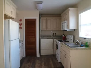 Kitchen with fridge, cabinets, oven, stove with cooking range and window