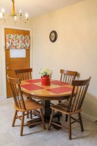 A dining room with a round table and chairs.