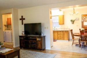 A living room with a tv and a dining table.