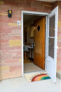 A door to a house with a rainbow on it.