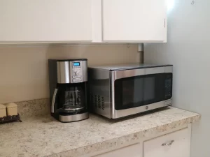 coffee maker and microwave oven with kitchen cabinets on top and bottom