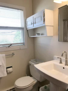 Washroom with white cabinet and basin with window