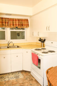 Kitchen sink, with cooking range and white cabinets