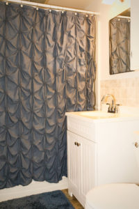 Black shower curtain with white sink