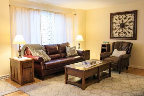 A living room with brown leather furniture and a coffee table.